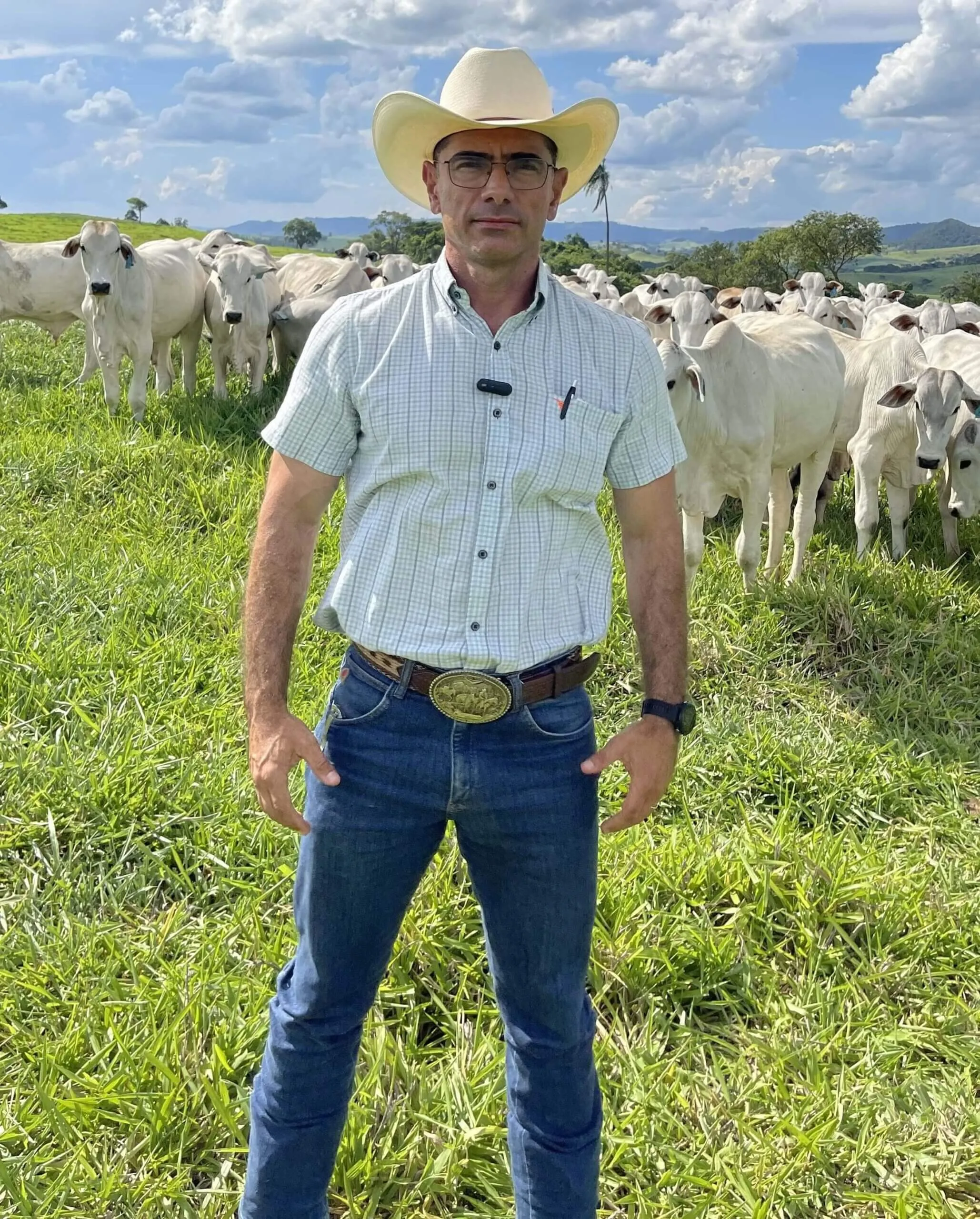 Marcus Camargo em uma fazenda, ao lado de gado de corte.